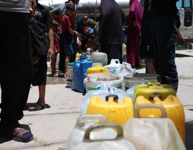 A line of jerrycans at a water distribution site in Gaza. 